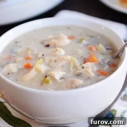 A small crockpot filled with creamy chicken and wild rice soup, perfect for an inviting dinner.