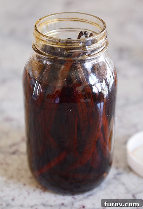 a glass mason jar filled with soaked vanilla beans