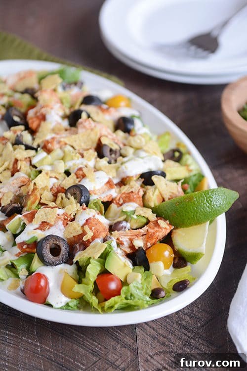 Chicken Taco Salad Your Way: Instant Pot, Slow Cooker, or Stovetop 2 A large bowl with a chicken taco salad loaded with toppings and drizzled with dressing.