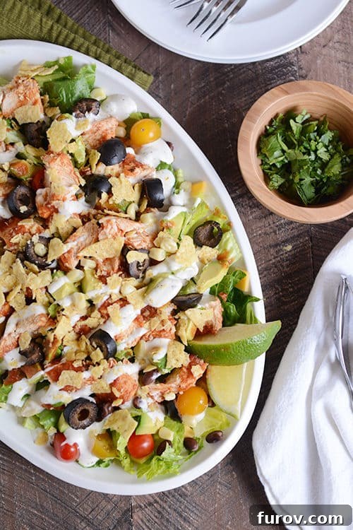 Chicken Taco Salad Your Way: Instant Pot, Slow Cooker, or Stovetop 3 A white oval bowl full of a chicken taco salad drizzled with dressing.