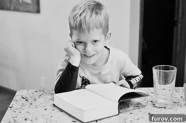 Unleash Imagination: Our Favorite Summer Reads for Kids 2 A little boy engrossed in a large chapter book, sparking imagination.