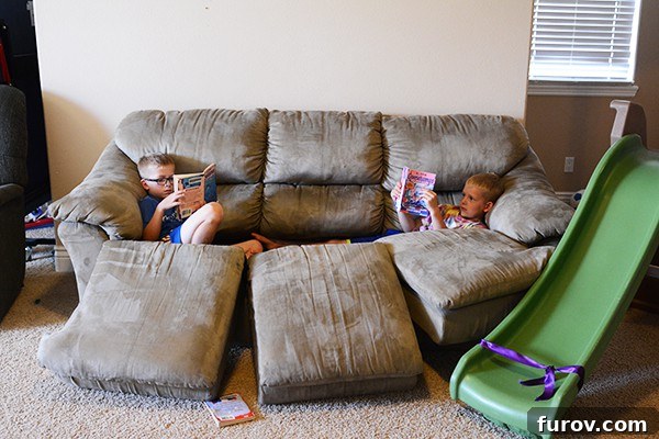 Unleash Imagination: Our Favorite Summer Reads for Kids 4 Two children lost in their books, comfortably reading on a couch with no cushions.
