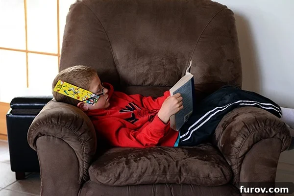 Unleash Imagination: Our Favorite Summer Reads for Kids 10 A relaxed little boy lying on a recliner, completely absorbed in his book.