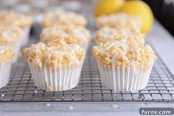 Frosting drizzled lemon crumb muffins on a cooling rack. 