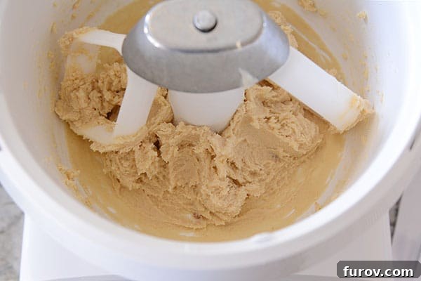 Close-up of butter and sugar creaming together inside the white bowl of a Bosch Universal stand mixer, highlighting its mixing action.