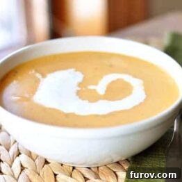 Butternut Squash Tomato Bisque Soup in a bowl with cream swirl.