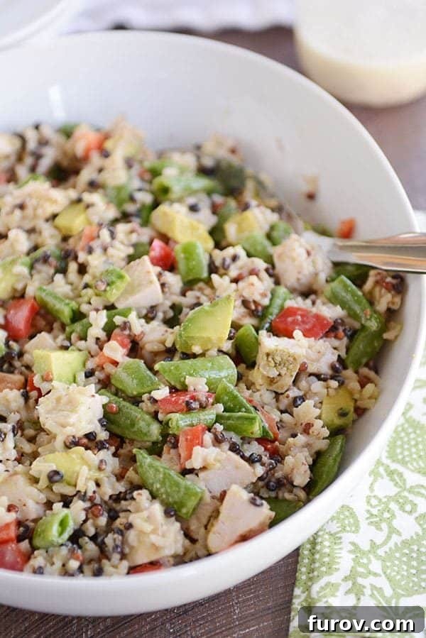A large oval white bowl of santa rosa chicken and wild rice salad. 