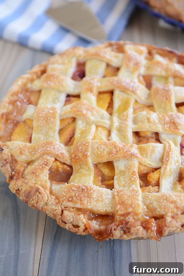 Juicy Fresh Peach Pie with Lattice or Crumb Topping 2 A beautifully golden-brown lattice-topped fresh peach pie, showcasing juicy peach filling beneath.