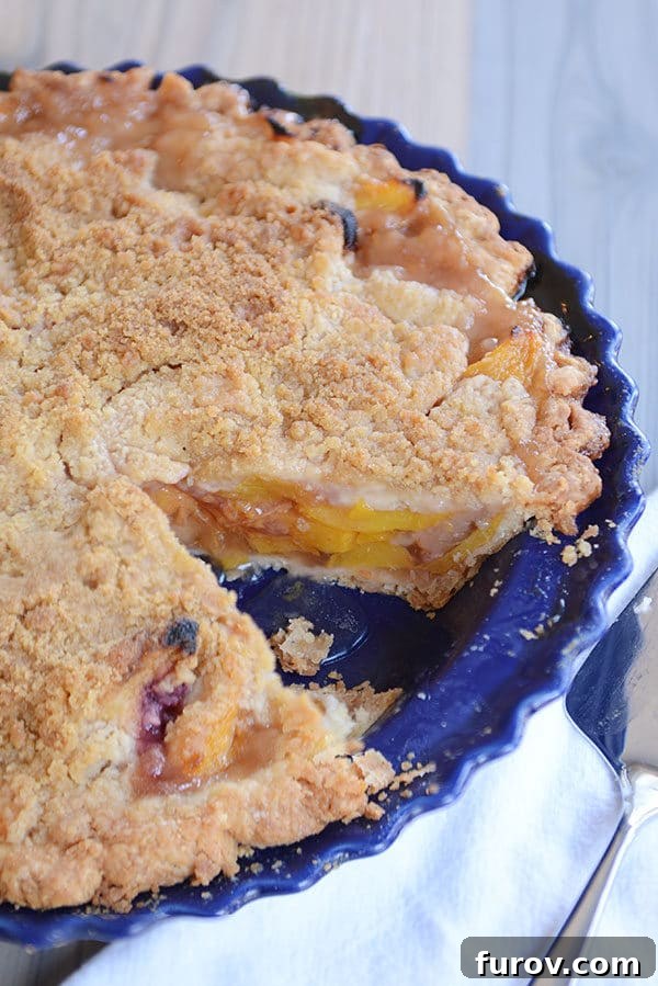 Juicy Fresh Peach Pie with Lattice or Crumb Topping 5 A vibrant peach pie baked in a rustic blue pie dish, a slice already enjoyed.