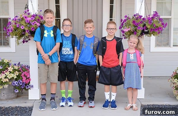 Five kids standing on their front porch on their first day of school, looking excited and ready for the new academic year.