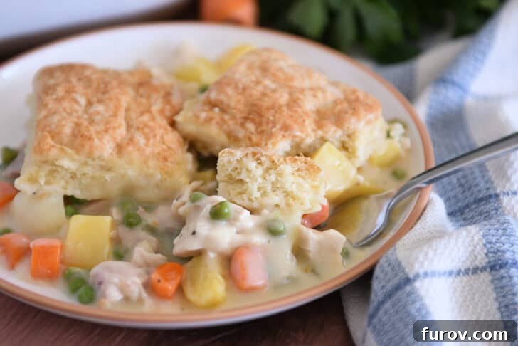 The Perfect Chicken or Turkey Pot Pie 8 Fork scooping bite of chicken pot pie with small piece of baked biscuit.