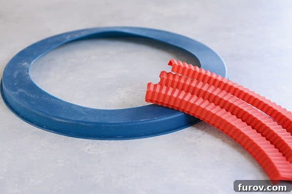 Kickstart Your Pie Making: Essential Tools and Ingredients 11 A blue silicone pie crust cover ring and several red crimped pie crust covers, designed to prevent over-browning.