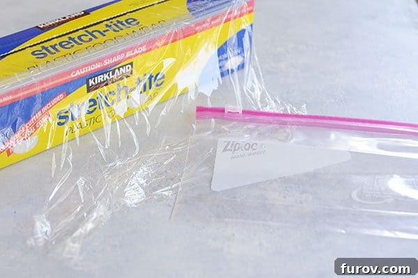 Kickstart Your Pie Making: Essential Tools and Ingredients 9 Saran wrap and a Ziploc bag on a white countertop, showing useful items for pie dough storage.