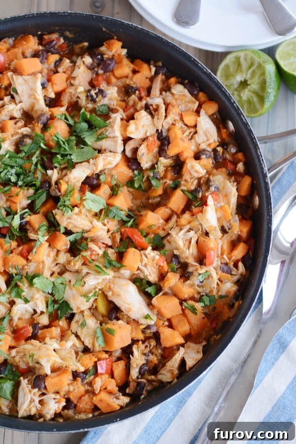 A vibrant skillet filled with cheesy Mexican chicken and sweet potato, ready to be served.