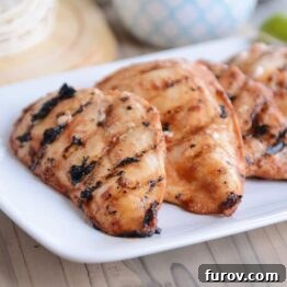 Three pieces of chipotle grilled chicken on white platter, showcasing the beautiful char.