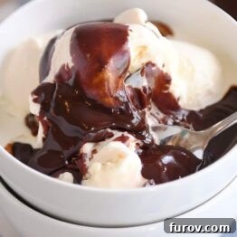 Vanilla ice cream in white bowl with 5-minute hot fudge sauce on top, illustrating the recipe result and inviting indulgence.