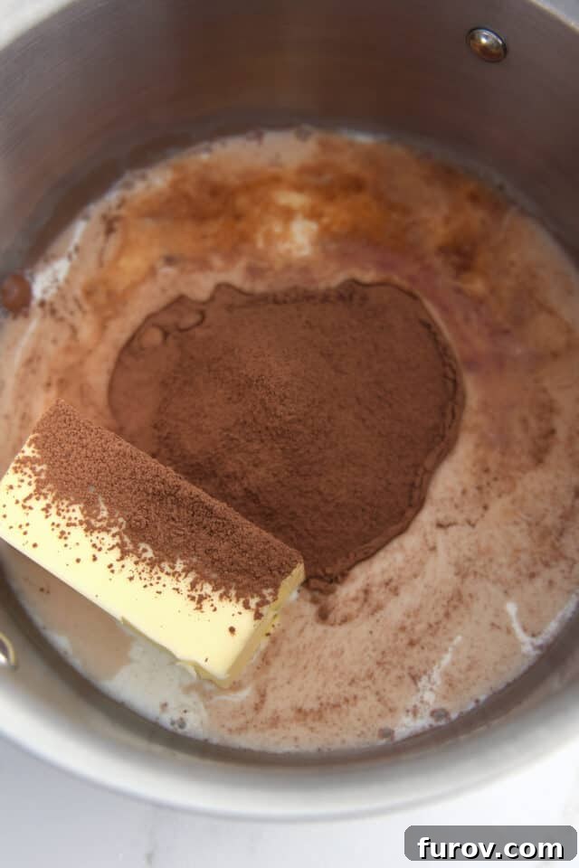 Butter, cocoa powder and milk in saucepan. Preparing the stovetop chocolate frosting base.