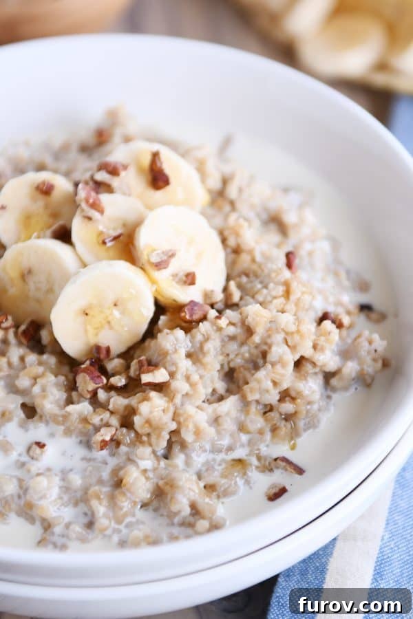 Comforting Instant Pot Banana Bread Steel Cut Oats 2 Close up of white bowl filled with Instant Pot banana bread steel cut oats with sliced bananas and milk.