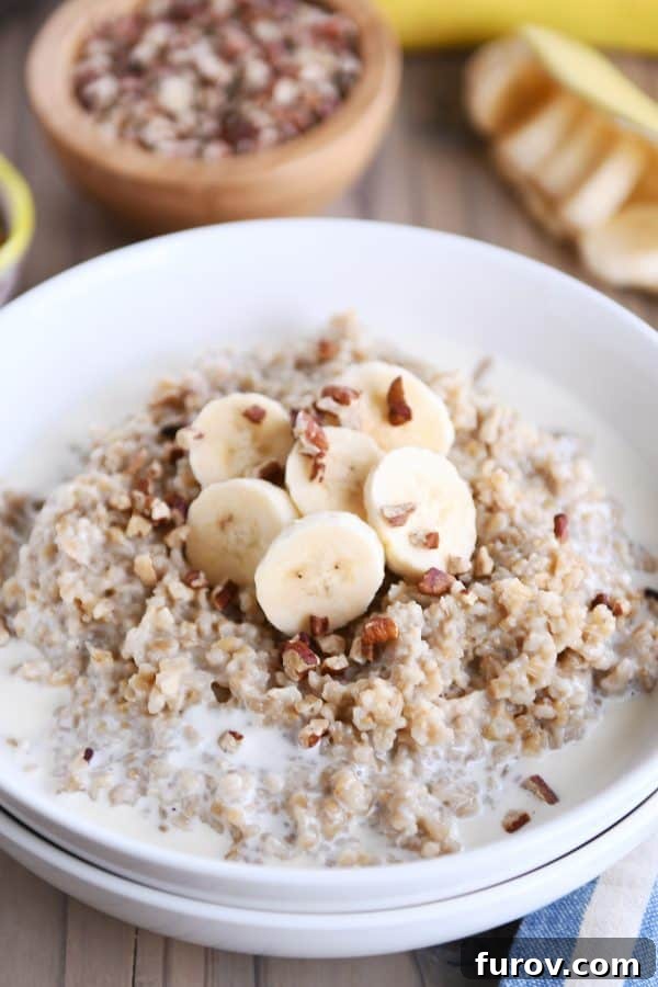 Comforting Instant Pot Banana Bread Steel Cut Oats 6 White bowl filled with Instant Pot banana bread steel cut oats with sliced bananas and milk.
