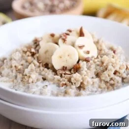 White bowl filled with Instant Pot banana bread steel cut oats with sliced bananas and milk.