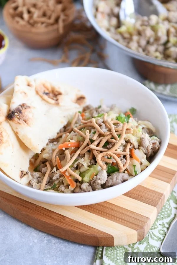 One-Pan Egg Roll Bowl 4 Ground turkey, cabbage, naan in white bowl.