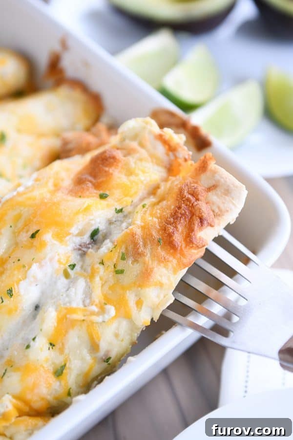 Scooping out honey lime chicken enchilada with flat metal spatula.