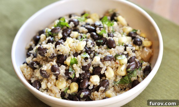 Close-up view from above of the vibrant black bean, sweet corn, and quinoa salad in a white bowl, showcasing the colorful ingredients.