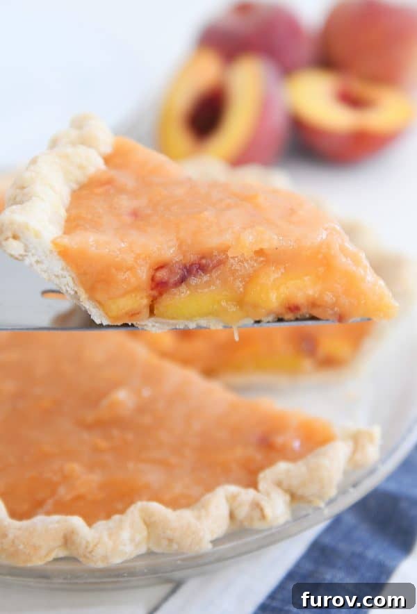 Slice of fresh peach pie on pie server.