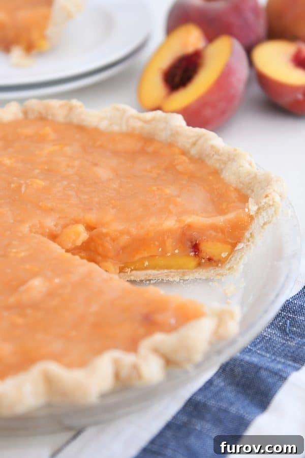 Fresh peach pie with slice removed.