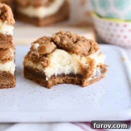 Spiced Gingerbread Cheesecake Bars 8 gingerbread cookie cheesecake bar with bite taken out on white tray