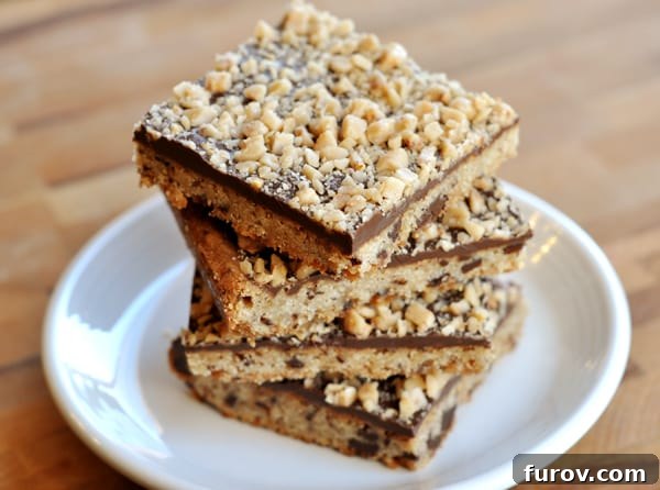 Chocolate toffee shortbread bars stacked on top of each other on a white plate.