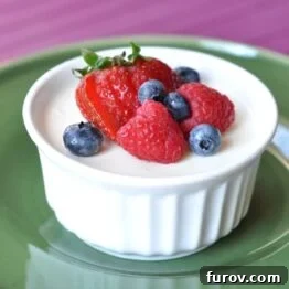 small white ramekin filled with cream and topped with fresh berries
