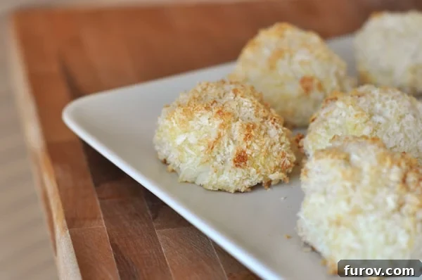 Homemade Baked Potato Puffs 3 A white ceramic plate showcasing several round, golden-brown potato puffs, highlighting their crisp exterior.
