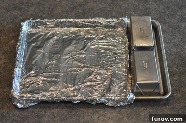 Deep South Chocolate Decadence 4 A standard baking sheet covered in tinfoil, with two small bread pans used to create a custom baking area for the cake.