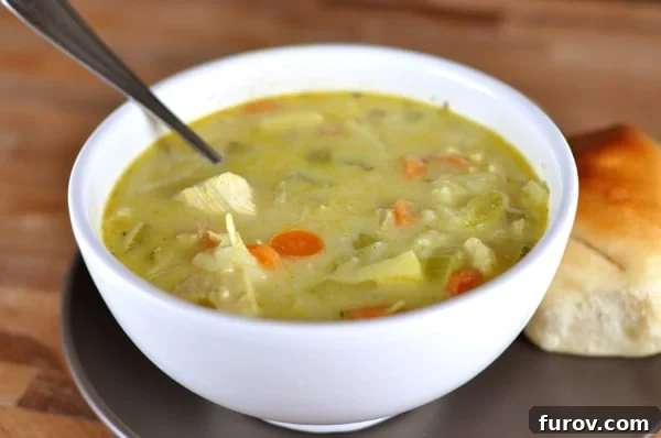 Exotic Mulligatawny Warmth 2 A beautiful white bowl brimming with hearty chicken and vegetable mulligatawny soup, garnished with fresh herbs, ready to be enjoyed on a cozy evening.