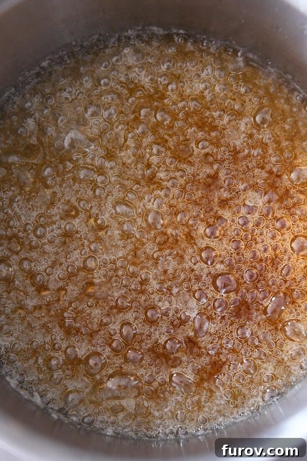 From Scratch Golden Caramel Bliss 9 Caramelized sugar mixture in a saucepan, reaching a deep amber brown color, indicating readiness.