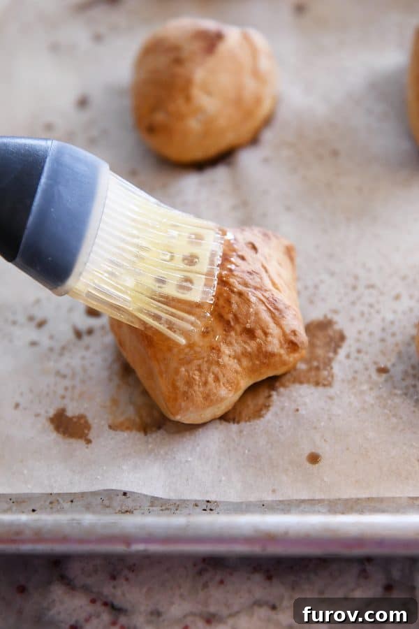 Irresistible Homemade Pretzel Bites 16 Brushing baked pretzel bites with butter.