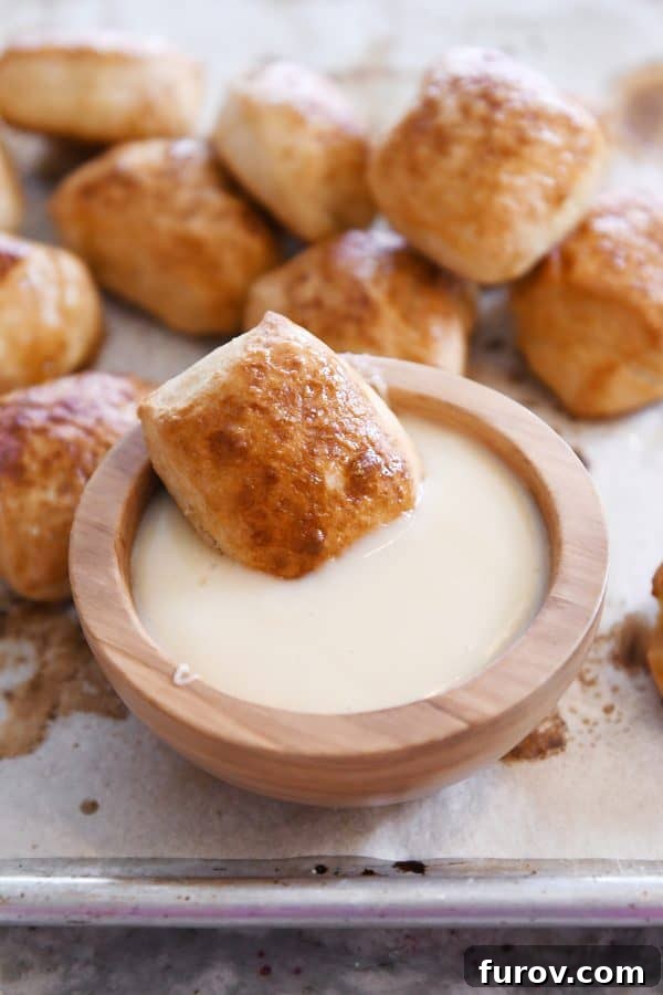 Irresistible Homemade Pretzel Bites 18 Soft pretzel bite sitting in bowl of warm cheese sauce.