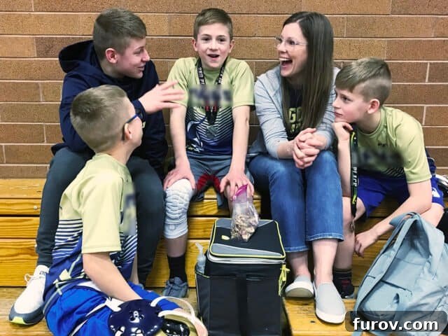 Four young boys in wrestling singlets, huddled together, looking determined.