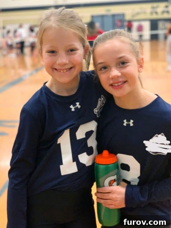 A young girl in a volleyball uniform, smiling on a court, embodying the joy of youth sports.