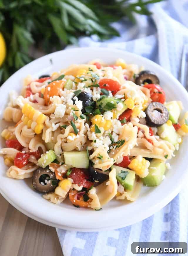 Zesty Mediterranean Pasta Salad 6 Serving of Greek pasta salad on white plate.