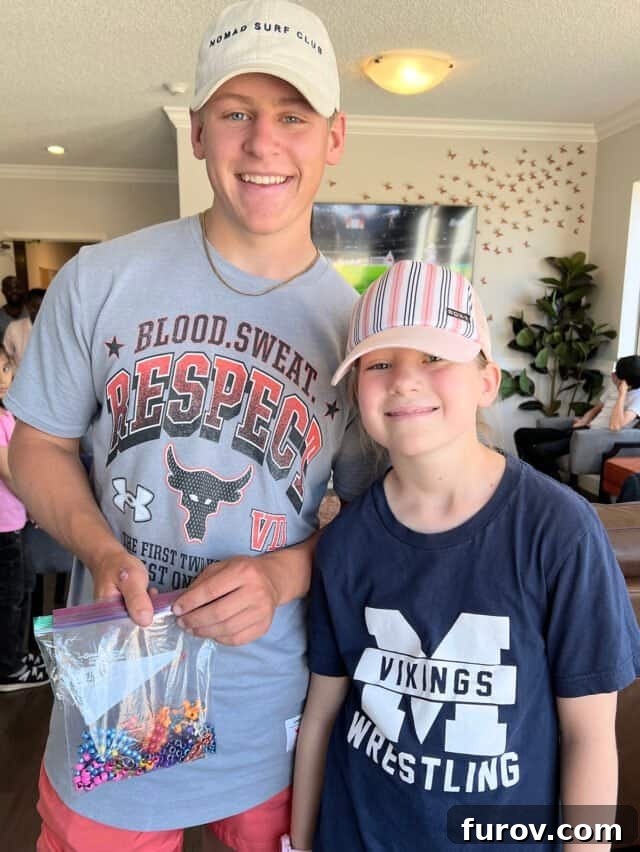 Boy and girl holding bag of beads.