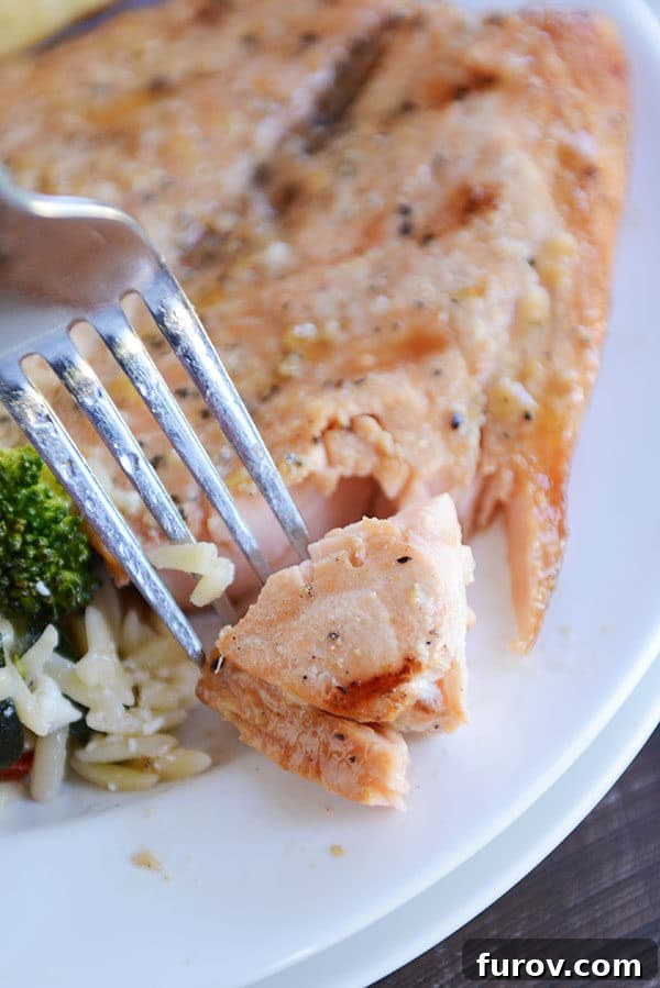 Succulent Grilled Salmon 3 A fork taking a bite out of a grilled fillet of salmon.