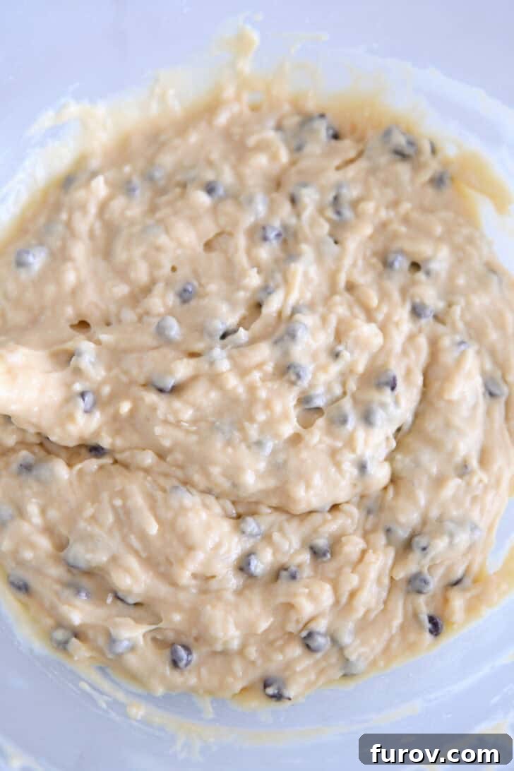 Coconut Almond Bliss Muffins 5 The final almond coconut chocolate chip muffin batter mixed together in a glass bowl, ready to be scooped.