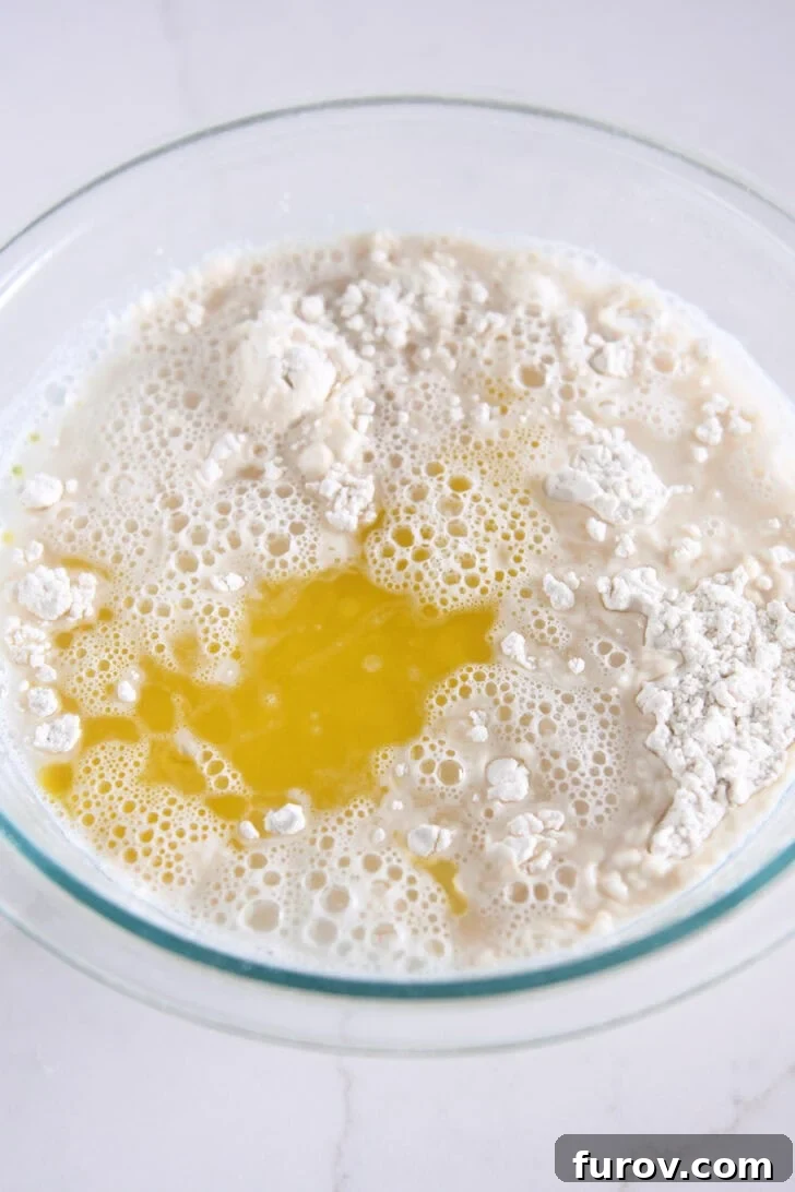 Foolproof No Knead Fluffy Focaccia 5 Water and olive oil being added to the dry ingredients to form the focaccia dough.