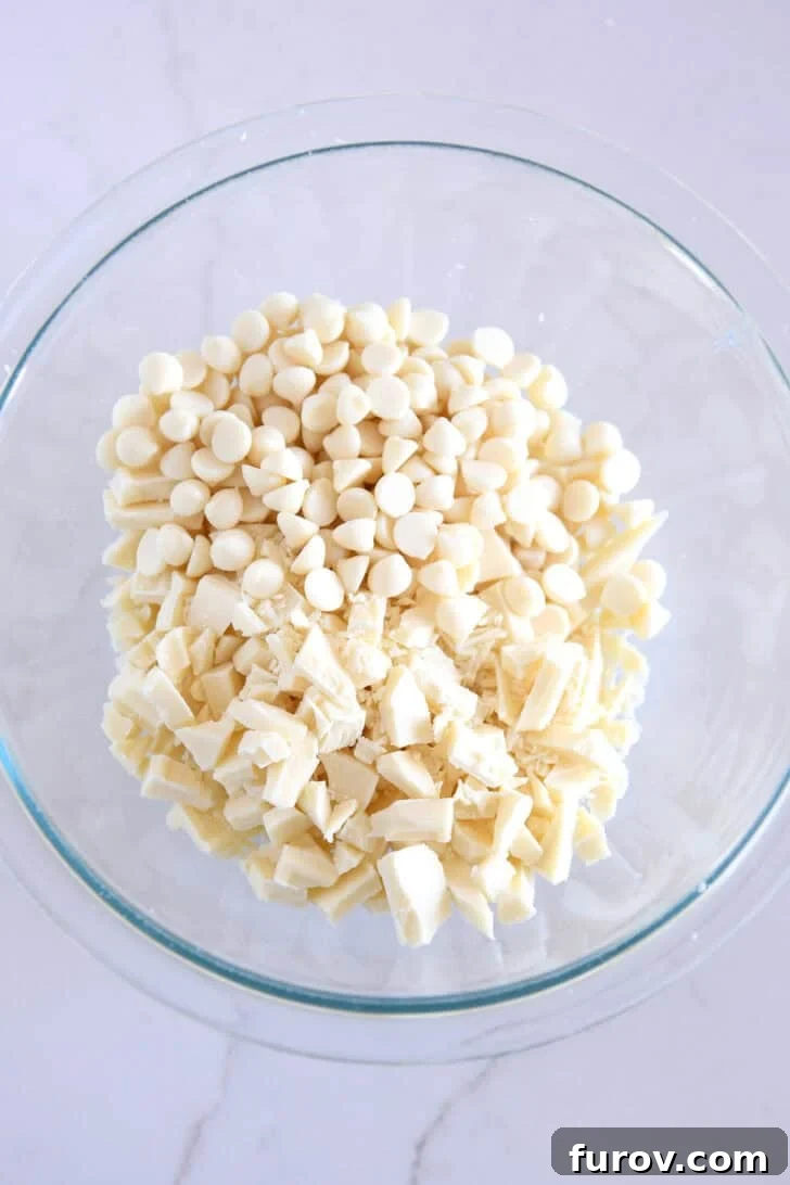 Glass bowl with chopped white chocolate and white chocolate chips.