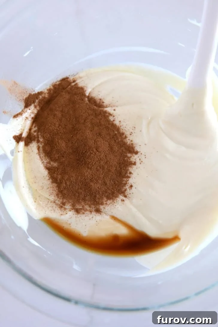 Glass bowl with melted white chocolate, vanilla, and ground cinnamon.