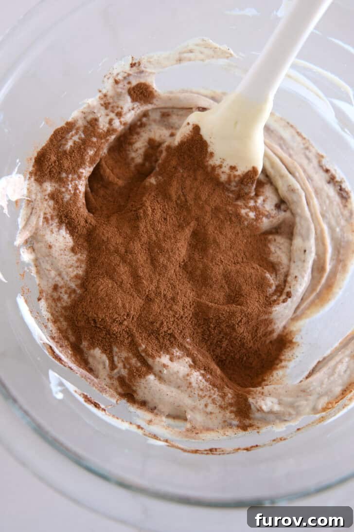 Glass bowl with melted white chocolate and ground cinnamon.