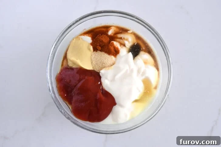 Ketchup, mayonnaise, mustard, garlic powder, Worcestershire sauce, paprika and vinegar in glass bowl.