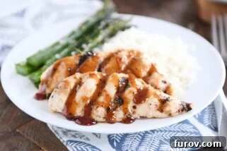 sticky coconut chicken on white plate with coconut rice and asparagus